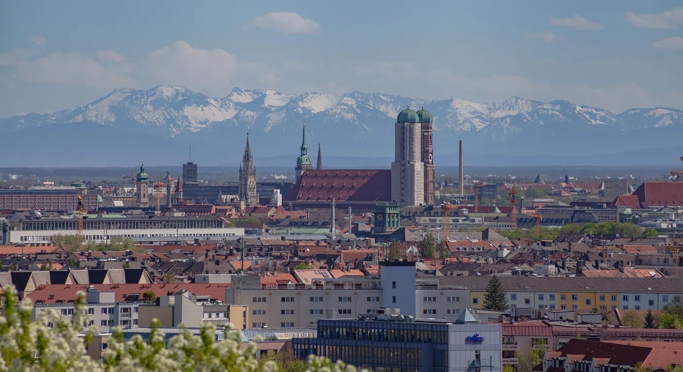Blick vom Olympiapark über München mit Frauenkirche und Alpen – Monteurzimmer in München