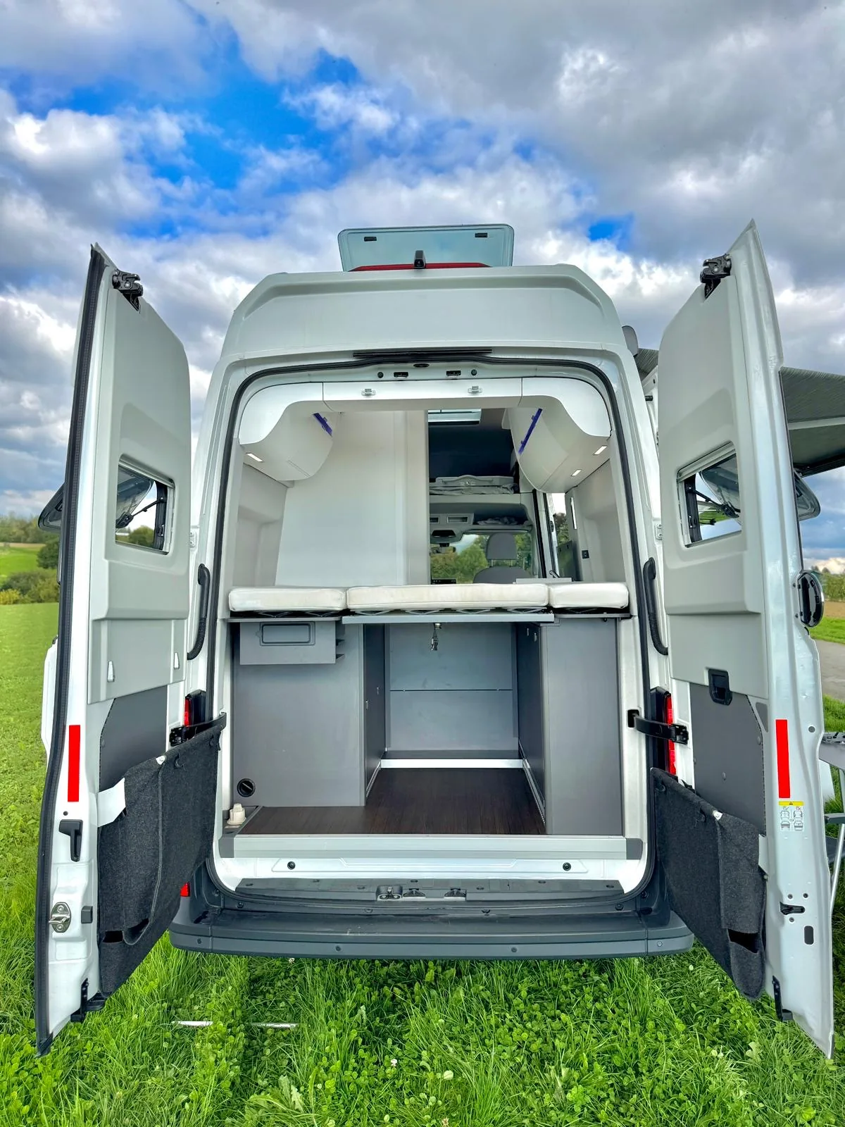 VW Grand California Hecktüren vollständig geöffnet – Blick auf Schlafbereich und Stauraum