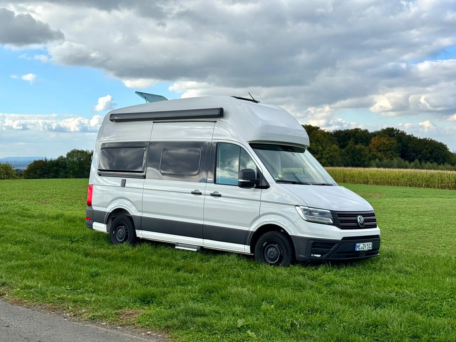 VW Grand California Premium Camper – makellose Außenansicht auf grüner Wiese in NRW
