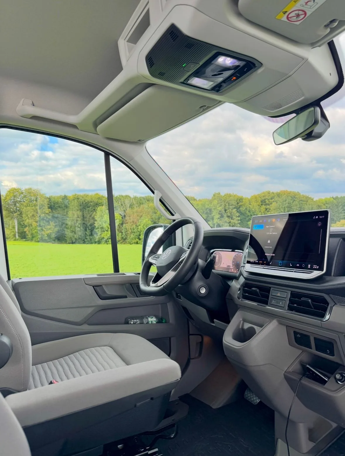 Fahrerbereich des VW Grand California von innen – Lenkrad, Digitalcockpit und Naturblick
